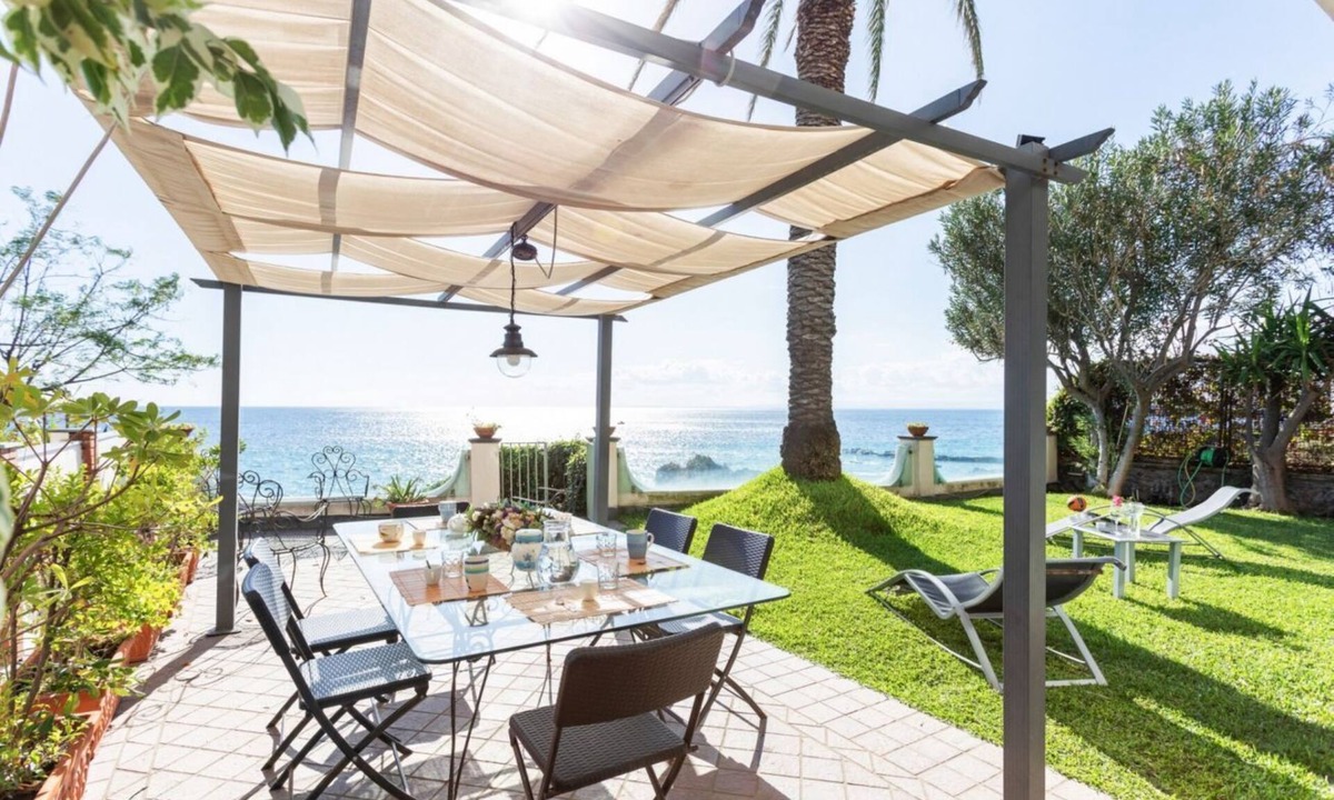 Picanello-Ognina-Barriera-Canalicchio Apartment | GuestHost - This spacious seafront 150 square meters apartment can accommodate up to 6 people. Located on the ground floor, the apartment has a garden overlooking the sea, with a stunning view and private access to the sea on a neighbors shared platform.
