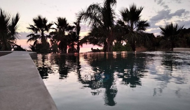 Ancient sea and sunset view millstone with swimming pool