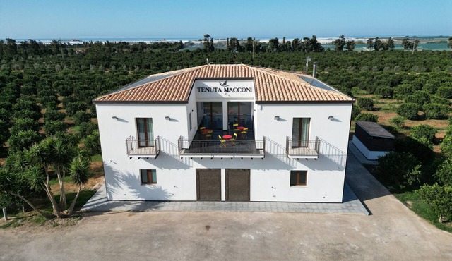 Tenuta Macconi Country Rooms, nestled in a lush citrus grove near the sea.